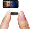 Small camera device held between two fingers with a smartphone screen displaying video footage.